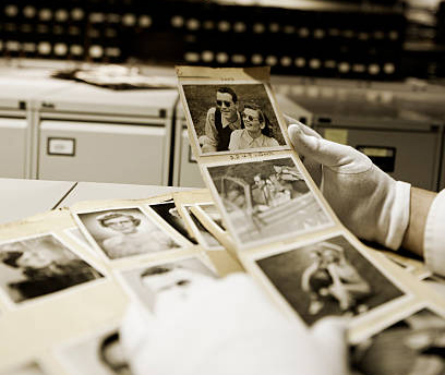 Photo restoration and digitation process, showing gloved hands gently treating the images with care as they are being archived and digitized